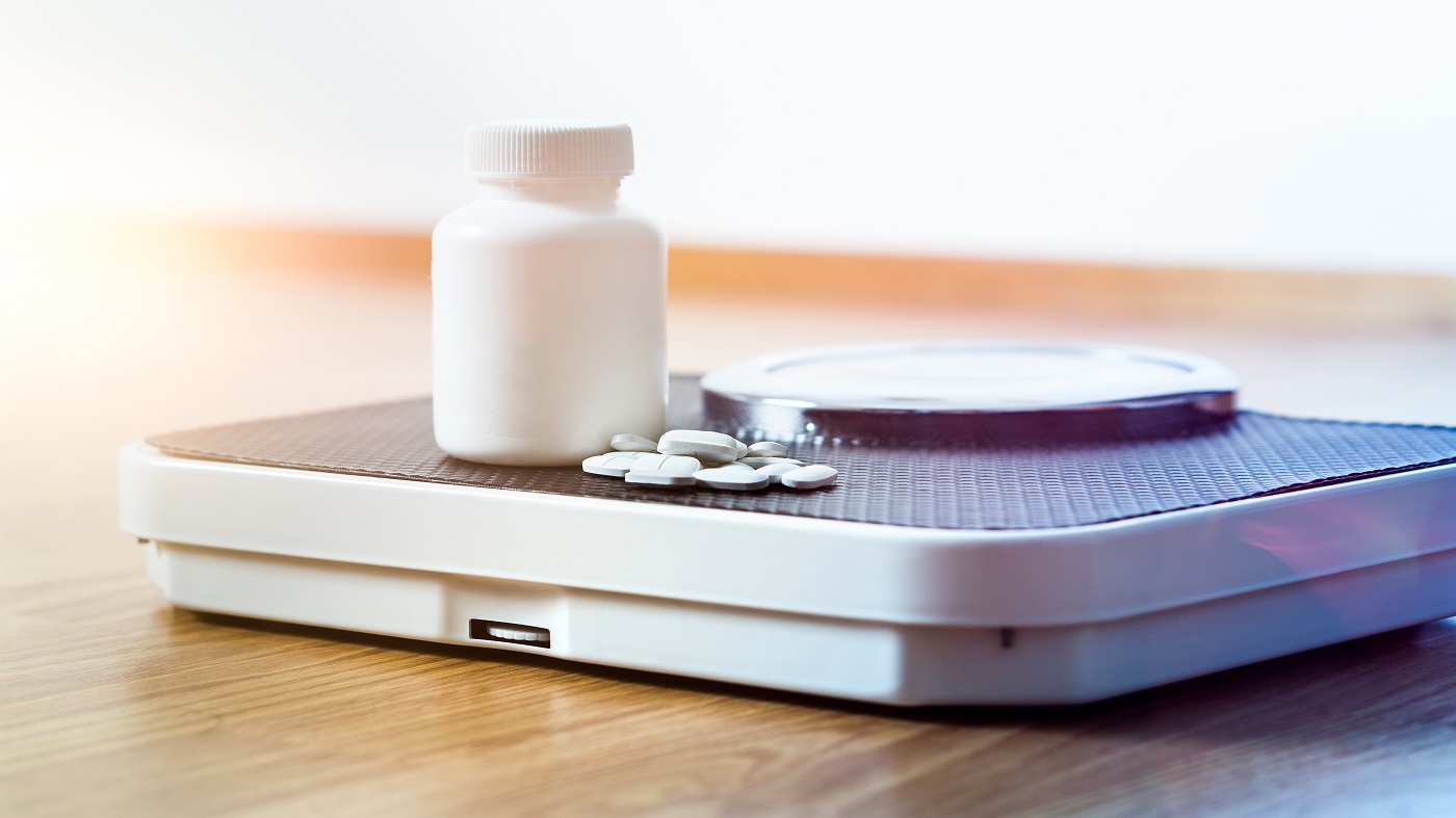7-Keto DHEA for Weight Loss? -- supplement and pills on scale