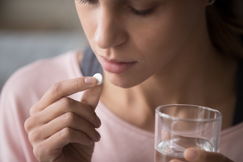 Woman Taking Pill with Glass of Water